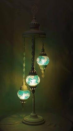 three lights that are sitting on top of a tablecloth covered floor in front of a green background