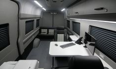the interior of an airplane with desks and computers on it's side walls