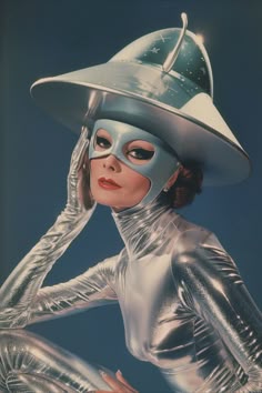 Travel back in time to the era of pulp comics with 'Space Age Chic', a vibrant depiction of a 1950s woman dressed in a striking silver bodysuit, complete with a UFO-inspired mask and hat. This image captures the fascination with space and science fiction during the 1950s, reflected in her bold, futuristic outfit. The silver ensemble shines against the backdrop of imaginative pulp comic adventures, embodying the era's dreamy visions of galactic exploration. 80s Futuristic, 50s Space Aesthetic, 50s Space, 60s Futuristic Aesthetic, Retro Futuristic Aesthetic, Space Age Costume, Retrofuturism Fashion, Retro Futuristic 50s, 60s Futurism