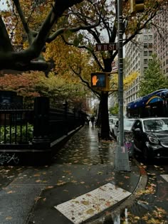 a city street with cars parked on the side of it and people walking down the sidewalk