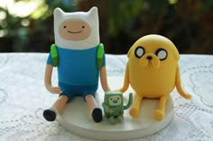 two toy figures sitting on top of a table