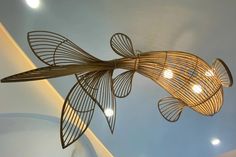 a metal fish sculpture hanging from the ceiling