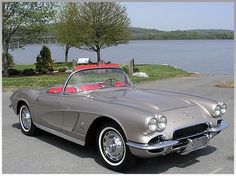 an old car is parked near the water