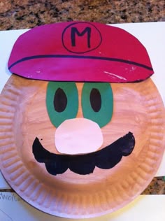 a paper plate that has a mario mushroom on it's face with a red hat and moustache