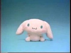 a white stuffed animal sitting on top of a blue surface