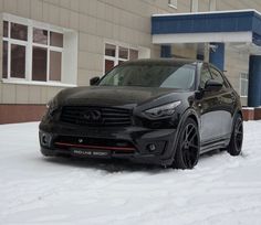 a black suv parked in the snow near a building