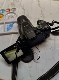 a camera sitting on top of a table next to a cell phone and other items