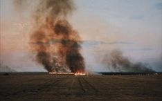a large fire is burning in an open field