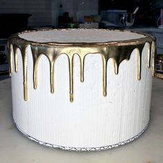 a white cake with gold drips on it