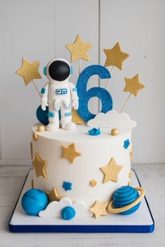 a birthday cake with an astronaut on top and stars in the sky, for a 6th birthday