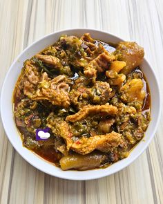 a white bowl filled with food on top of a wooden table