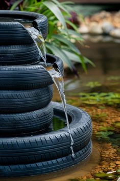 several tires stacked on top of each other with water running from them to the ground