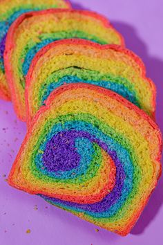 several slices of rainbow bread on a purple surface