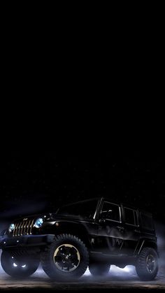 a black jeep driving down a street at night