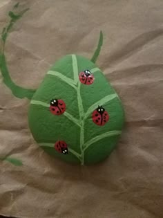 a green rock with ladybugs painted on it