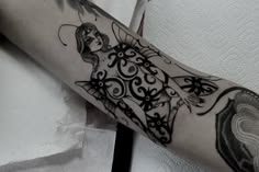 a woman's arm with an intricate tattoo design on the left side of her arm