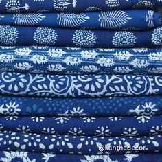 a stack of blue and white printed fabrics