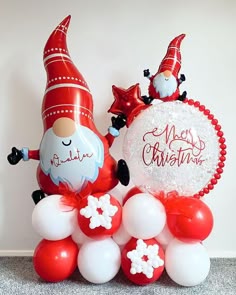 some balloons that are sitting on the ground and one is santa clause with snowflakes