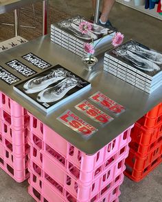 several stacks of pink and orange crates with pictures on them sitting on top of each other