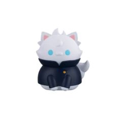 a white and black cat figurine sitting on top of a white surface with blue eyes