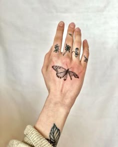 a woman's hand with a butterfly tattoo on it