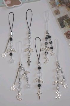 four different necklaces with charms hanging from it's sides on a white surface