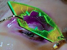 a close up of a person's eye with colorful makeup