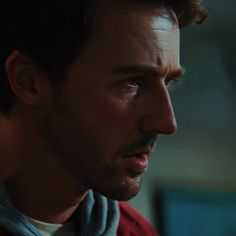 a close up of a person wearing a hoodie and looking at something in the distance