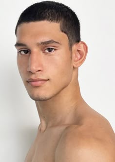 a young man with no shirt on posing for the camera in front of a white background