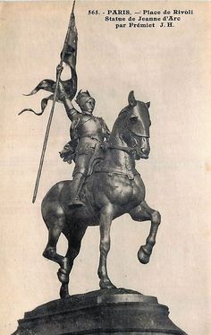 a statue of a man riding on the back of a horse next to a flag