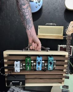a person is holding an electric guitar case in front of some guitars and amps
