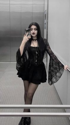 a woman is taking a selfie in the mirror with her cell phone while wearing black