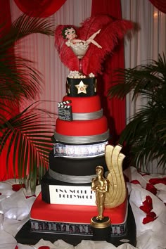 a red and black wedding cake with an angel on top