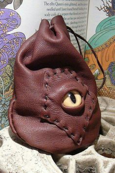 a brown leather purse with eyeballs on it