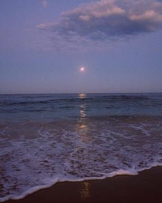 the moon is setting over the ocean with waves