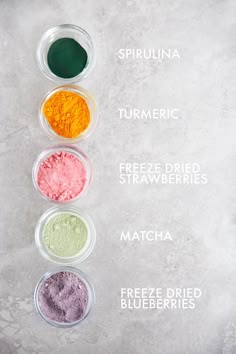 four different colored powders in small bowls on a white surface with the words, spiruna turmetic, freeze dried strawberries, matcha and freeze dried blueberries