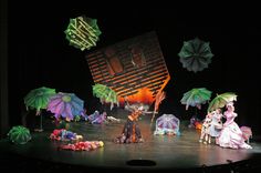 people are performing on stage with umbrellas in the air