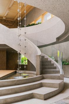 a spiral staircase with glass balls hanging from it's sides in a modern building