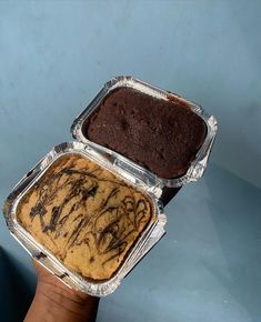a person holding two pans of food in their hands, one with chocolate frosting on it