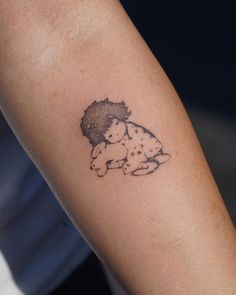 a person with a tattoo on their arm holding a teddy bear in the shape of a heart