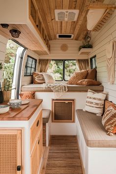 the inside of a small camper with wood flooring and white walls, windows, and lots of natural light