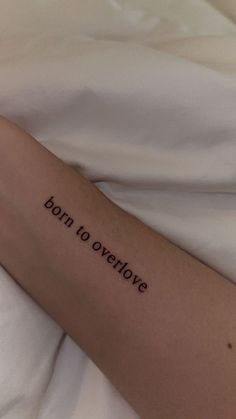 a woman's arm with the words born to overdrive written on it in cursive font