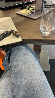 a person sitting at a table with their feet up on a piece of paper next to a cell phone