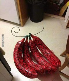 a person holding three red umbrellas in their hand on the floor next to a kitchen counter