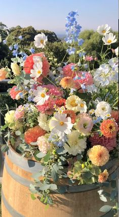 a bunch of flowers that are sitting in a barrel