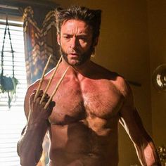 a shirtless man holding two sticks in his hand