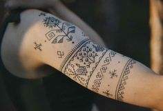 a woman's arm with a tattoo on it that has an arrow and stars