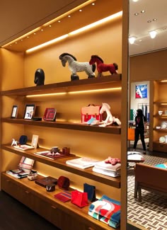 there are many different items on the shelves in this store, including horse figurines