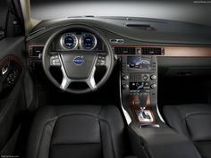 the interior of a car with black leather and wood trims, including steering wheel