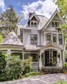a large white house surrounded by trees and bushes
